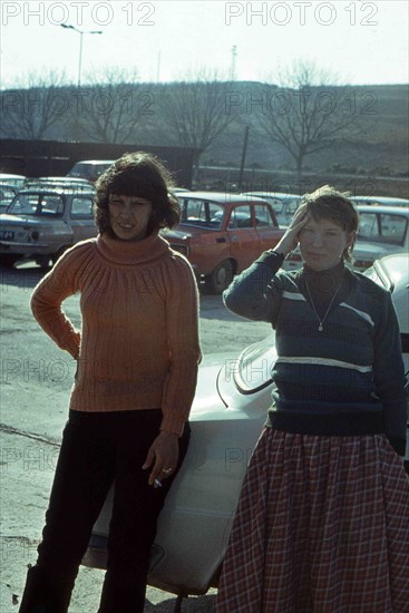 Two young Caucasian women posing near a Skoda car.