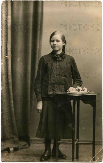 A girl standing near the table.