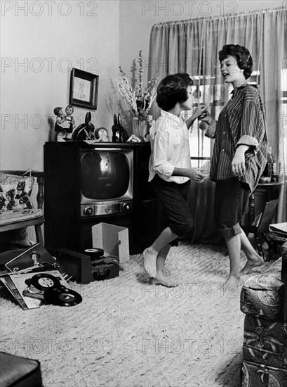 Young women dancing at home.