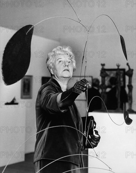 Peggy Guggenheim portrait in front of an Alexander Calder sculpture.