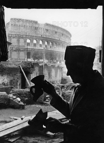 Worker dusts off amphora finds near the colosseum.