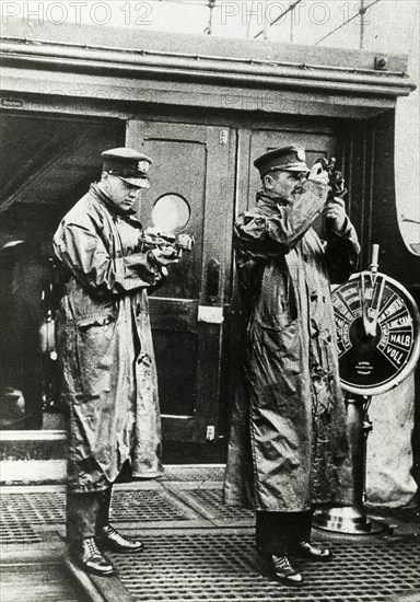 Command Bridge Of A British Ship, Two Officers Are Studying The Route.