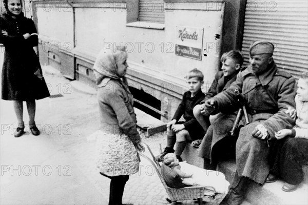 II world war, berlin, russian soldier plays with a young girl