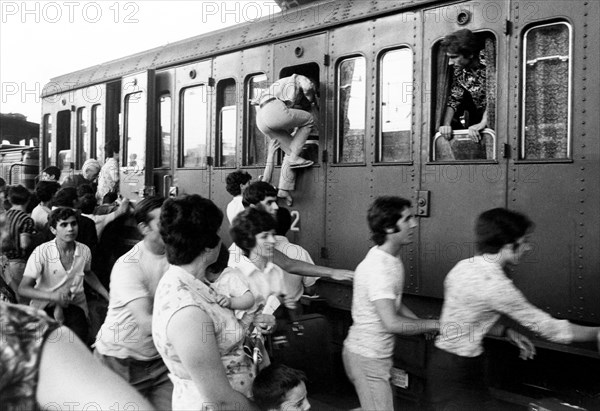 Passengers at the station during the summer exodus, italy 70s