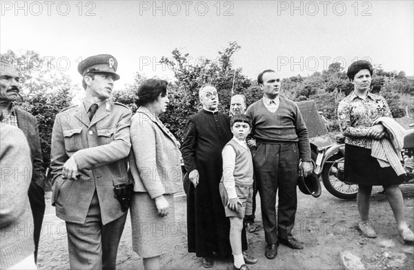 Police force, priest and a group of people, 70's