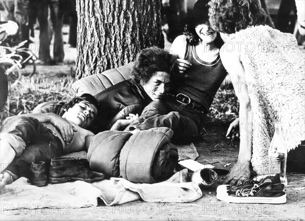 Four persons with sleeping bag and a bottle of coke, 70's