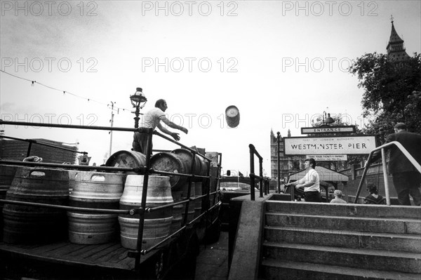 Workers loading barrells on truck at westminster pier, london, uk, 70's