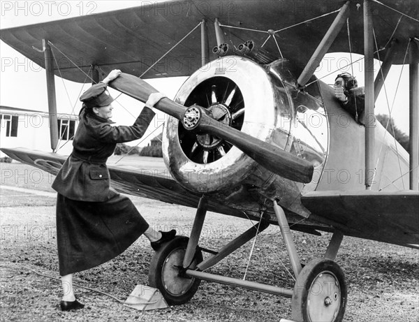 A woman in military uniform 20 years' starts the engine of an airplane, 1962