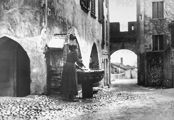 Woman Washing Hands In Fountain.