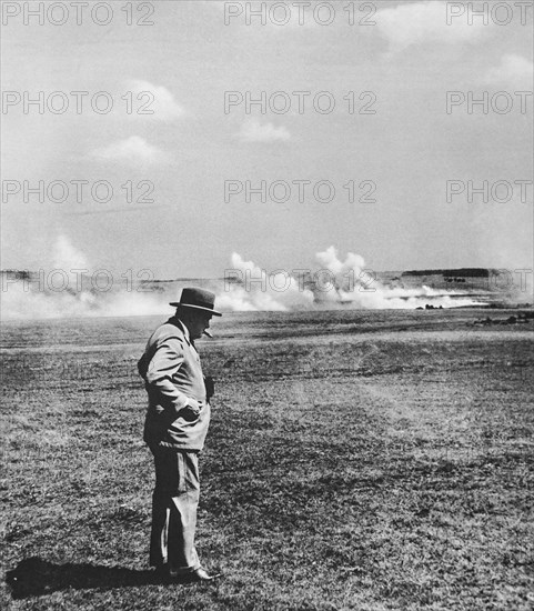 Mr Churchill, cigar in mouth watching realistic mock battle in the Southern Command using live ammunition.