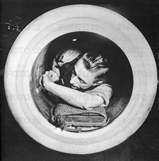 Preparing the worn inner tube of a massive naval gun whilst at sea.