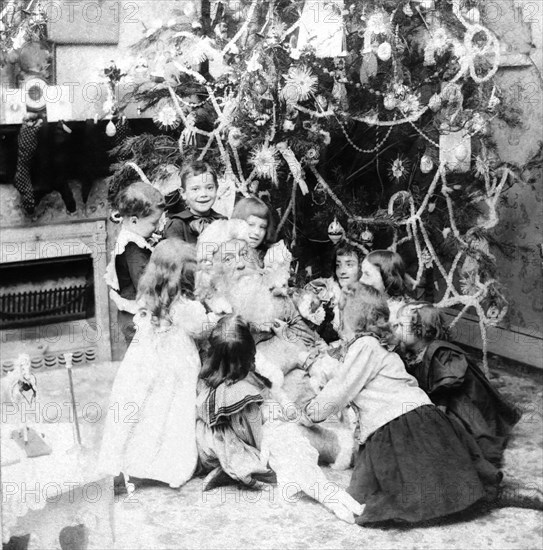 Santa Claus with lots of children and a Christmas tree.