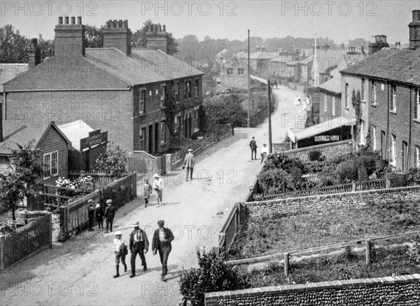 A typical street scene around 1910 with little boys in the street wearing flat caps.