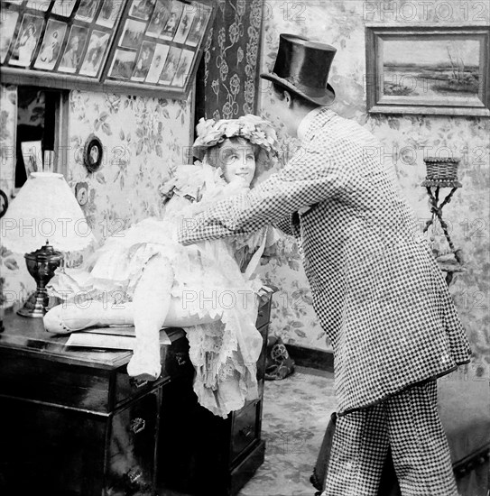 Lady on desk with man holding her.