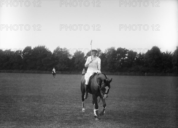 Man on horse at the end of a game of polo.