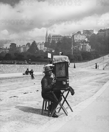 Blind beggar man playing a barrel organ in Bute Torquay.