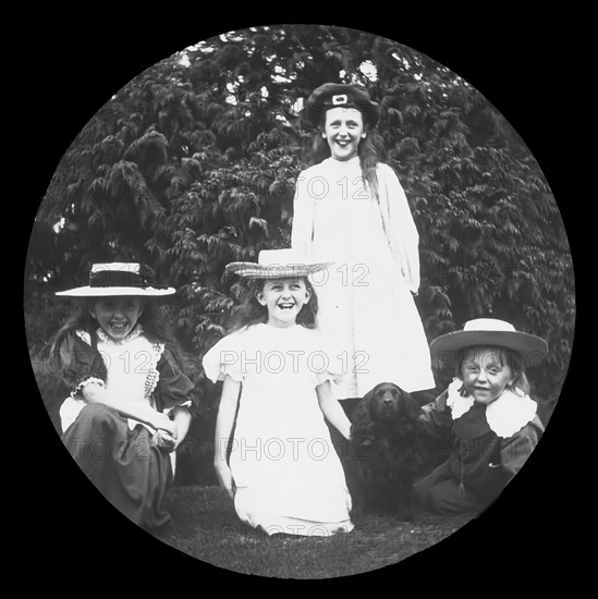 Four children and a dog pose for a family photograph.