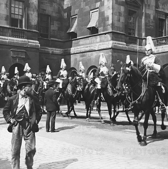 A poor street man walking past Horse Guards parading.