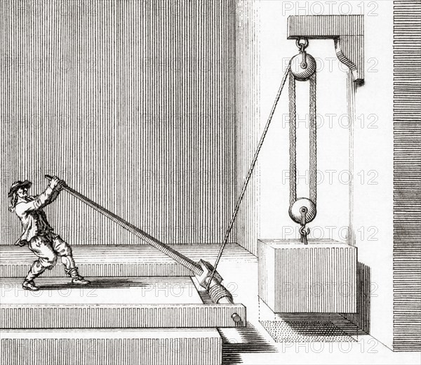 Man operating a pulley with a lever and fulcrum.