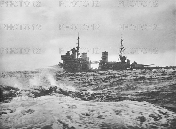 King George V war ship steaming full speed ahead in high seas.