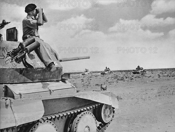 British Commander of a light calavary tank keeping a look out as his unit advances.