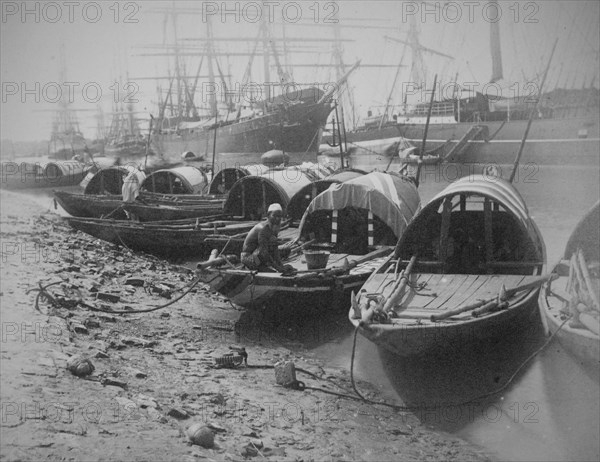Sampans and sailing ships moored on a river inlet in Calcutta