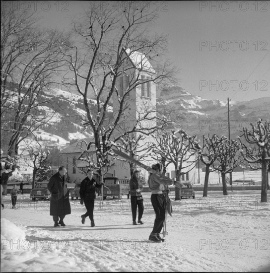 Lenk; passerby carrying skis; 1957.