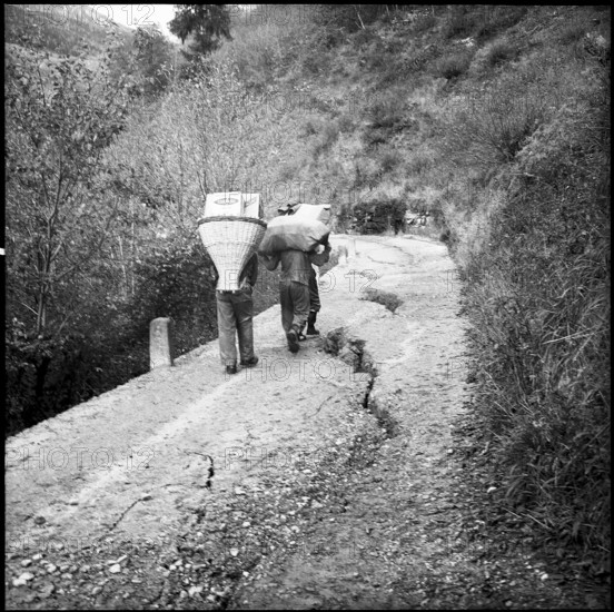 Landslide in the Misox valley, men carrying goods to supply the population; 1960.
