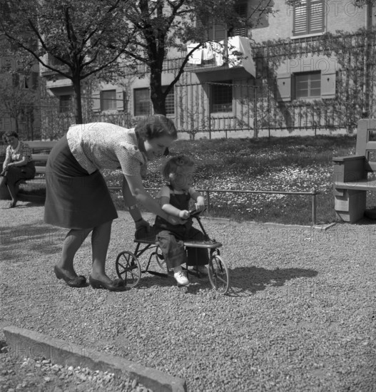 Mother and daughter playing outdoors, Switzerland 1940.