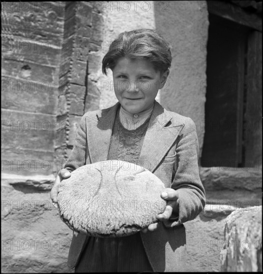 Boy with freshly baked bread in St. Luc, Valais, in 1941.