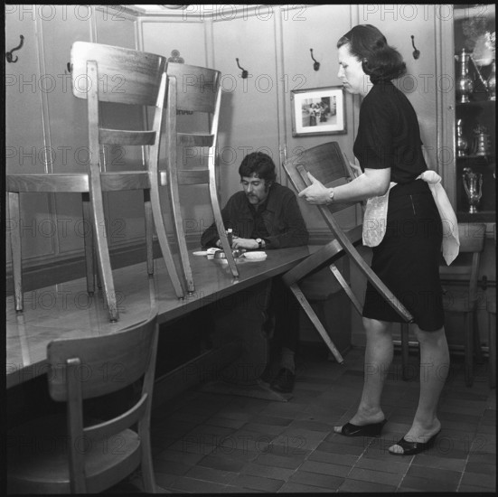 Closing time; Waitress putting chairs on tables 1969.