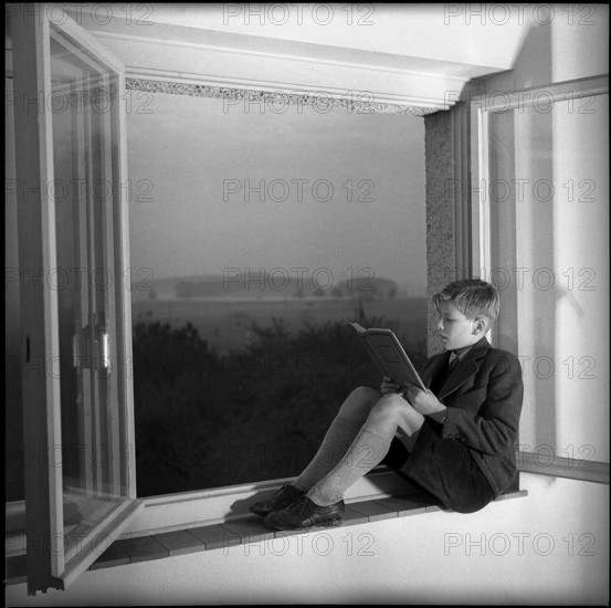 Male Teenager Reading in Community Home.