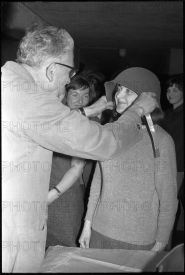 Woman soldier getting helmet, armoury Kreuzlingen 1964.