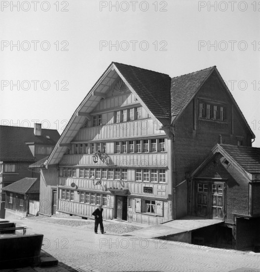 Herisau; Old man walking in a street; 1945.