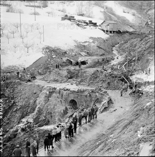Avalanche in Nendaz, people looking at the devastation; 1957