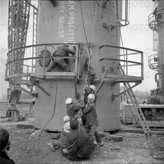 Refinery Collombey, assembly, workers pulling a rope; 1962