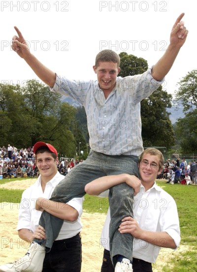 Photo: walter l. keller, 2.9.2006, interlaken: unspunnenfest 2006. 1. federal young swingers' day unspunnen 2006. festival winner marcel mathis (m, born 1988) cheers on the shoulders of his swinging colleagues