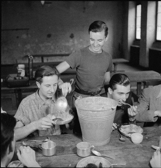 WW2: farming camp; young men eating, 1943