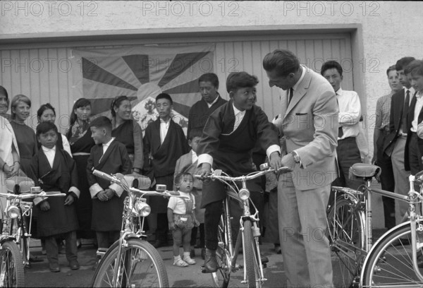 Ferdy Kübler presenting four bicycles to Tibetan pupils, Oetwil 1965