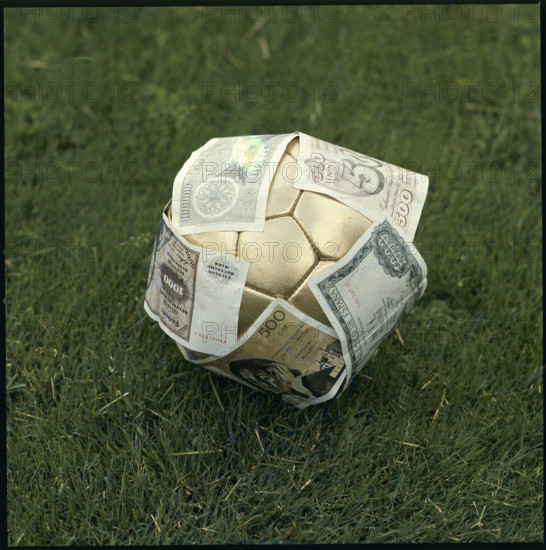 Golden football, having banknotes stuck all over