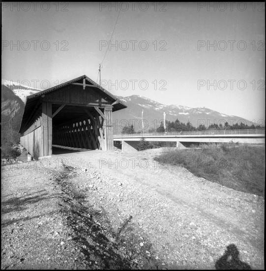 Roofed wooden bridge next to new built Rhine bridge; 1958