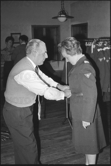 Woman soldier getting uniform, armory Kreuzlingen 1964
