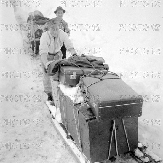 Bedretto valley, evacuation because of danger of avalanches 1951: men leave the village walking, belongings on sleighs
