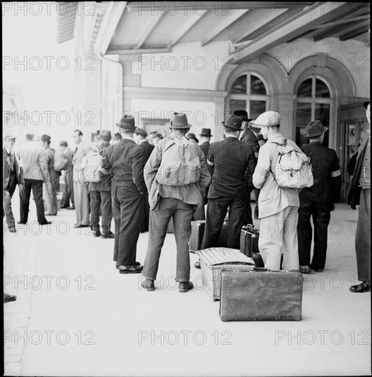 WW2: farming camp; men arriving at train station, 1942