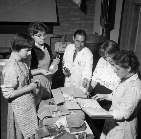 Young women and teacher discuss proceeding for creation of jewel