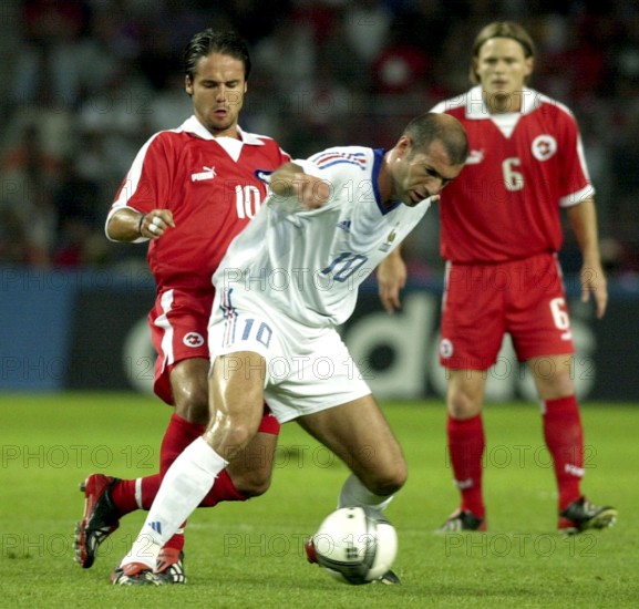 Photo: walter l. keller, 20.8.2003, geneva: friendly match switzerland - france 0:2. zinedine zidane (m, fra) fighting for the ball against ricardo cabanas (l, sui), johann vogel (r) watched.