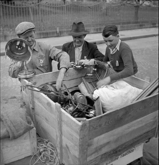 Men collecting nonferrous metal, handcart; 1942