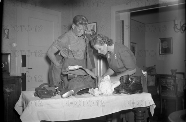 Mobilization report 1947: The conscript packs his suitcase with his mother/wife