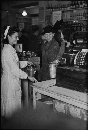 Saleswoman serves customers in a grocery store; 1945