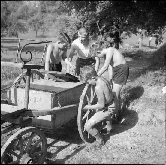 Children transporting peat briquettes; 1940
